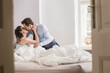 © Stefanie - Woman kissing husband and pulling him back into bed