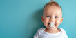 © dinastya - Smiling baby boy with pacifier portrait on flat blue background with copy space. Banner template with infant child smile.