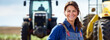 Woman agronomist smiles and shows thumbs up against the background of a tractor at sunset