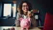 Cheerful young woman, wearing glasses ,sitting at a desk with a pink piggy bank