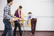 © Stefanie - Colleagues stacking chairs in a conference room. Munich, Bavaria, Germany