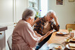 © Marko Geber - Senior man having headache during breakfast with wife in kitchen