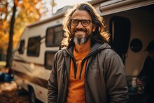 A Stylish Man, Clad In A Jacket And Glasses, Stands Confidently In Front Of His Rugged Rv, Ready To Embark On An Autumn Adventure On The Open Road