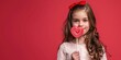Beautiful little girl holding heart shaped lollipop on red background. Valentine's Day Concept