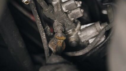 Poster - A mechanic unscrews the nuts with a tool to remove a part attached to the chassis of a truck. Close-up.