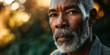 Elderly African American man with gray beard, intense gaze, golden hour light softening the background