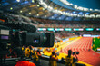 Telecast of professional athletics races. Media Coverage at Sports Event. Camera at modern stadium. Broadcasting and streaming, TV coverage in Paris. Modern athletics stadium in background
