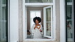 © stockbusters - Relaxed woman enjoying espresso cup window frame. African lady rest with coffee