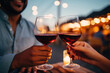 Hands holding glasses of red wine close up. Couple having date at restaurant, drinking alcohol