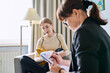 © Valerii Honcharuk - Young female teenager talking with counselor, teacher sitting in chair in office