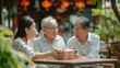 © Sasint - Asian couple surprised elderly father with Birthday gift at outdoor cafe restaurant on summer holiday vacation. Family relationship, celebrating father's day and older people health care concept.
