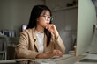 © bongkarn - A serious Asian businesswoman in eyeglasses is planning her project, working in the office.