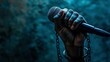 World press Freedom Day concept. Hand holding a microphone with chain on dark background, symbol of press freedom of speech freedom.
