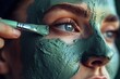 Woman applying a green mask on her face.