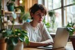 Angry freelance woman sitting with computer and macbook at table with confused and troubled expression