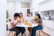 © JoseIMartin - A heartwarming scene of friends from various ethnic backgrounds sharing a laugh during breakfast