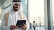 © pvl0707 - smiling young Middle Eastern man with a digital tablet, waiting at the airport terminal.