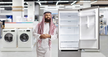 Canvas Print - Saudi arab man leaning on a fridge in a store