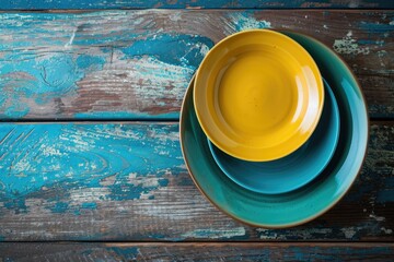 Poster - Copy space on the corner of an old wooden table with turquoise and yellow plates