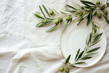 Wall Mural - Olive branch laid on white plate rustic background