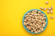 Salted pistachios for beer on yellow background. Healthy delicious pistachios in plate.