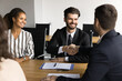 © fizkes - Company owner and project manager shaking hands over meeting table, smiling, discussing project success, investment, teamwork, successful partnership, working on cooperation, agreement
