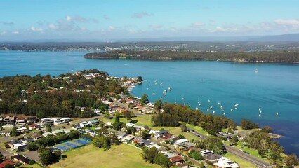 Wall Mural - Residential town on lake macquarie shore in Eleebana – aerial flying 4k.
