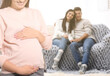 © New Africa - Surrogate mother and intended parents in room