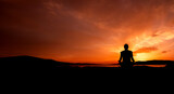 Fototapeta  - sylwetka kobiety medytującej na plaży przy zachodzie słońca	