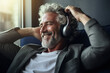 Mature man listening musical track in headphones