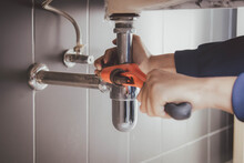 Plumber At Work In A Bathroom, Plumbing Repair Service , Fix Water Plumbing Leaks, Replace The Kitchen Sink Drain