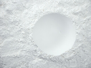 White flour texture background. Abstract powder texture. White powder surface with cracks and a round crater.