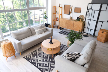 Sticker - Interior of light living room with grey sofas and coffee table near big window