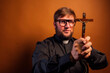 Portrait of an exorcist priest with crucifix and black shirt.