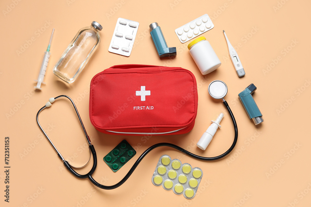 First aid kit and pills on beige background