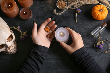 Wall Mural - Witch with burning candle on dark table