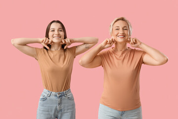 Poster - Beautiful women doing face building exercise on pink background