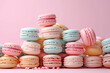 A generous heap of pastel-colored french macarons is tastefully piled against a pink background Mood suggests a perfect image for bakery advertising or culinary blogs