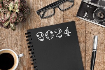 Sticker - New year 2024 resolutions notebook on desk.