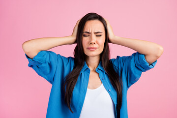 Sticker - Photo of overworked tired girl with straight hairdo dressed blue shirt palms cover ears eys closed isolated on pink color background