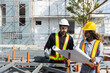 © eakgrungenerd - Construction civil engineer man and woman African American checking quality of work in construction site. Team of various nationalities working inspecting infrastructure building progress.