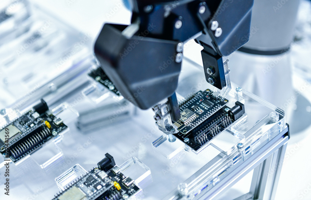 Modern Robot Arm automation system moving circuit boards in a factory ...