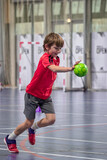 Détermination juvénile, enfant de huit ans gardien débutant arrêtant le ballon au handball
