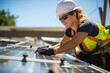 © Татьяна Евдокимова - Portrait of a female worker installing solar panels on a house roof on sunny day