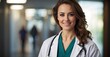 Happy young female doctor in a medical robe, wearing a stethoscope around her neck, displaying a confident and closed posture. Recorded in 4K with a 50mm lens