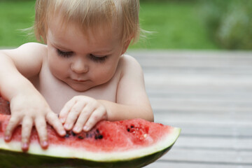 Boy, playing with watermelon and fruit in backyard, outdoor and development with growth, fruit and home. Toddler, child and infant in garden, alone and childhood to eat, milestone or coordination