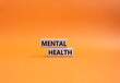 Mental Health symbol. Concept word Mental Health on wooden blocks. Beautiful orange background. Psychology and Mental Health concept. Copy space