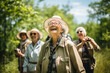 A spirited group of seniors engaged in a bird-watching excursion, appreciating the beauty of nature and fostering a sense of environmental awareness.