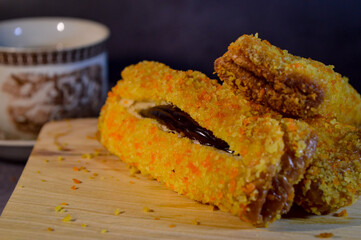 Poster - Roti goreng or fried bread with chocolate filling. sliced, on a wooden table.