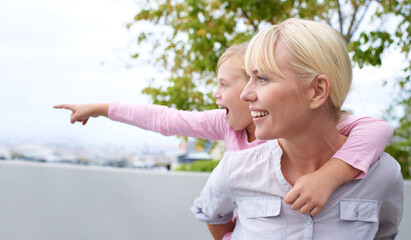 Poster - Happy, piggyback and mother with child pointing for sightseeing in nature, park or garden. Smile, fun and young mom carrying girl kid for bonding and playing together on an adventure in a field.